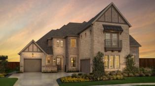 Two-story brick home with a three-car split garage.  Cedar trim accents and a second story balconly add detail to the front of the home.