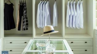 Building your dream closet by hanging shirts and dresses on wooden rails 